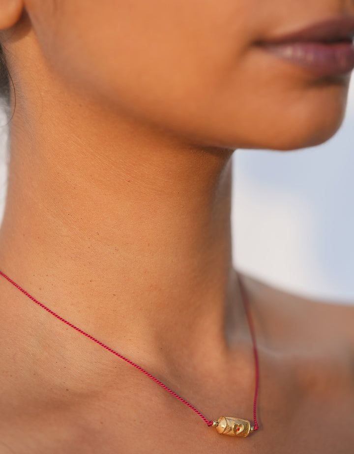 Choker Rakhi fil rouge avec pendentif grenat doré, symbole de protection et d'affection inspiré de la tradition indienne