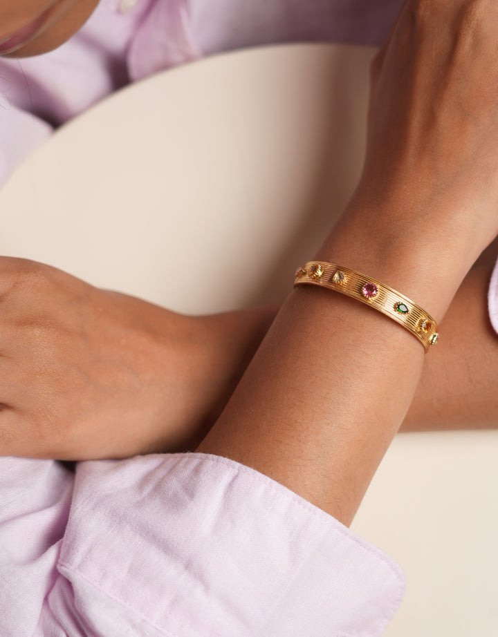 Jonc Divya Multico en laiton doré avec tourmaline, citrine et améthyste porté au poignet