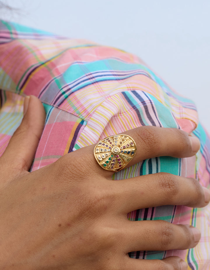 Bague Fortune Wheel portée sur la main avec chemise colorée