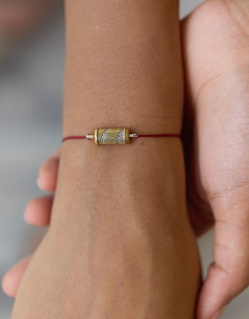 Bracelet Tabiz Spirale en topaze blanche porté au poignet, bijou talismanique en argent doré sur fil rouge